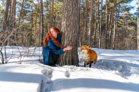 redhead girl in the forest with a fox