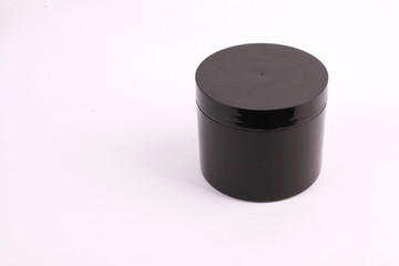 Black cosmetic containers on white background