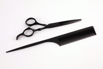 Barber scissors and a hairbrush isolated on white background