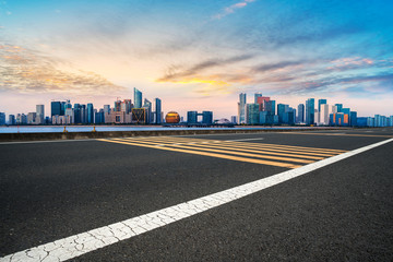 Obraz premium Foreground highway asphalt pavement city building commercial building office building