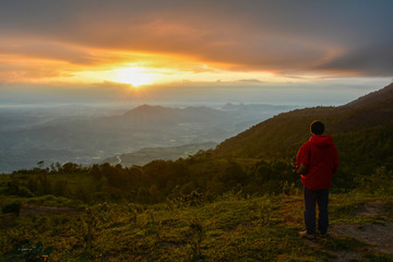 Man standing on hill mountain looking nature view beautiful sunrise or sunset