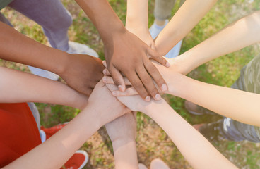Group of children putting hands together outdoors. Summer camp