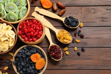 Flat lay composition with different dried fruits on wooden background, space for text. Healthy lifestyle