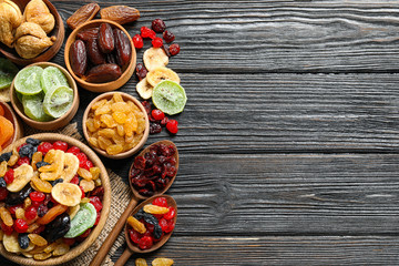 Flat lay composition with different dried fruits on wooden background. Space for text