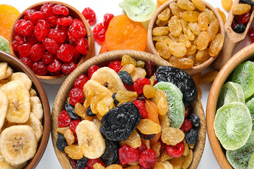 Bowls with different dried fruits on white  background, flat lay. Healthy lifestyle