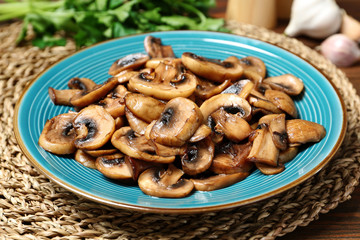 Plate of tasty fried mushrooms on table