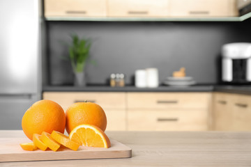 Fresh oranges on wooden table in kitchen. Space for text