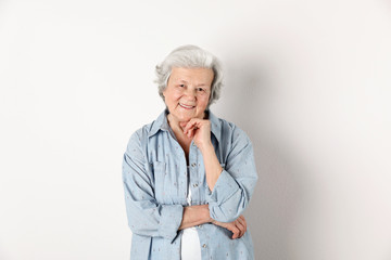 Portrait of grandmother in stylish clothes on light background