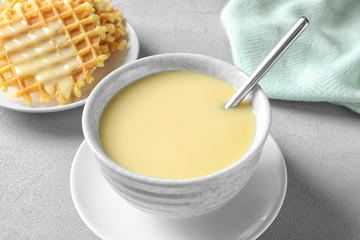 Bowl with condensed milk served on table. Dairy products
