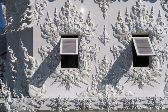 Persiennes ouvertes sur mur de temple blanc