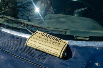 Warning notice on truck windshield to move car within 36 hours or be towed.