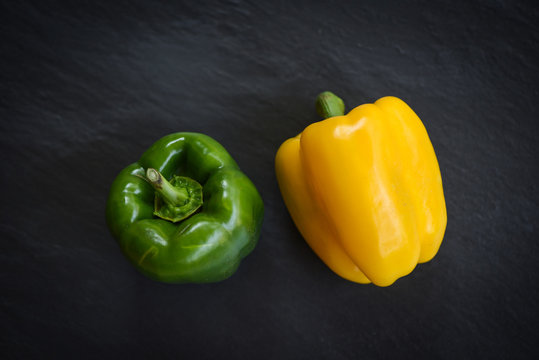 Fresh yellow and green sweet bell pepper on dark background