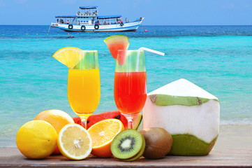 summer juice glass healthy foods / Many ripe fruit mixed on the beach blue sea