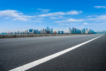 Obraz premium Foreground highway asphalt pavement city building commercial building office building