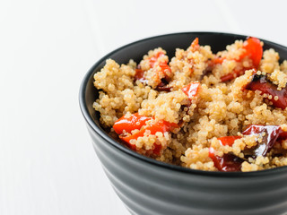 Boiled quinoa with baked pepper on a white table. Vegetarian dish.