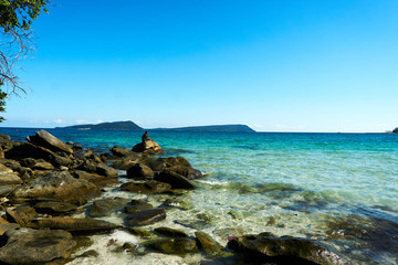 Fisherman is fishing at koh rong bay cambodia and sits on stones at the beach