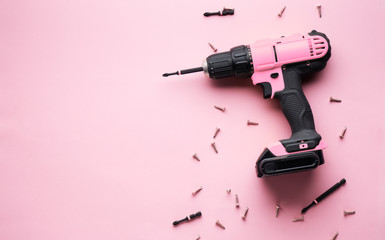 Creative provocation: a pink screwdriver on a pink background and small pink screws.