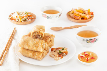 Traditional Chinese tortillas filled - bings in a plate on a white background, salads, Dam Sam snacks and cup of tea.