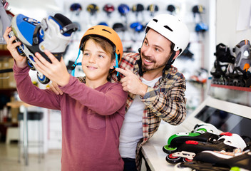 father and son deciding on new roller-skates in sports store