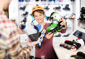 Adult male demonstrating roller-skates to boy
