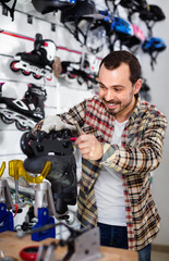 Male repairer fixing roller-skates in sports store