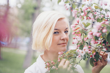 Fototapeta premium portrait of a beautiful blonde with short hair among flowers