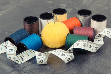 Spools of thread, needle and centimeter. Accessories for embroidery and sewing