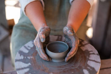 Potter is creating earthenware on potter's wheel.