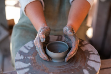 Fototapeta na wymiar Potter is creating earthenware on potter's wheel.