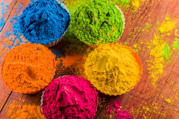 Vivid colorful Holi dye powder in cups. Shallow depth of field.