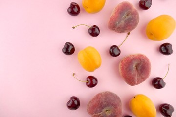 Summer fruits. fruits background mix flat lay. Apricots cherries, peaches on a  pink pastel background. top view, copy space.Summer season. Fruit season.