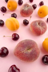 Summer fruits. fruits background mix flat lay. Apricots cherries, peaches on a light pink background. top view.Summer season. Fruit season.