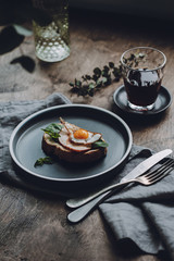 Ham and Fried Quail Egg Toast with Mustard and Basil on a dark wooden background, selective focus