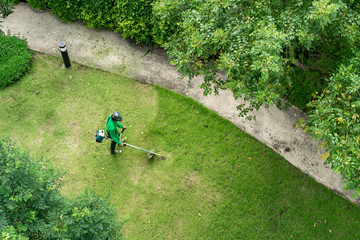 man worker cutting  grass with lawn mower