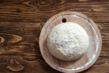 dough on a wooden Board, shot from above. with free text space.