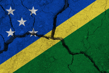 Solomon Islands flag on the cracked earth