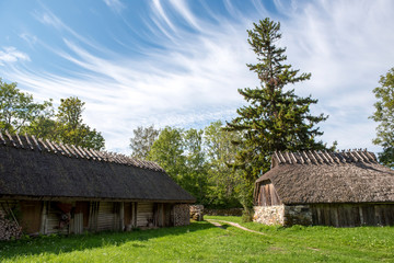 Fototapeta na wymiar Old barns with thatched roof in Estonia countryside (ethnographic museum)