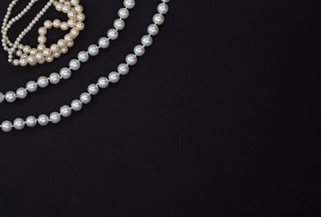 bracelet and pearl beads on black background with copy space