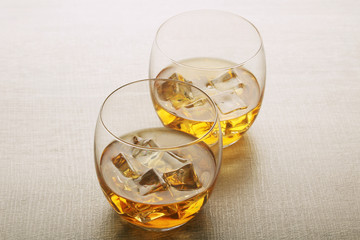 Two glasses with whiskey with ice cubes