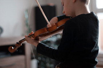 Handle hold violin shot from behind. Little boy carrying violin. Young boy playing violin, talented...