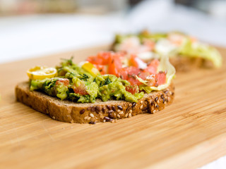 Open sandviches with guacamole, salmon and prawn on wood texture  background