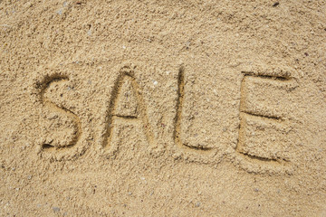 Sale word written on the sand at the beach, natural background