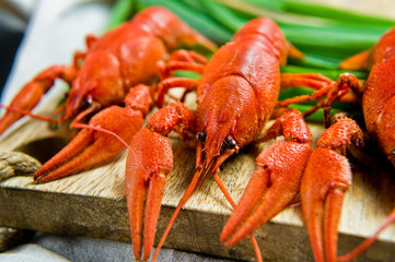 Boiled red crayfish on a wooden chopping Board. Black background, top view, close up.