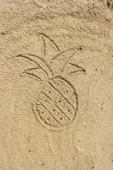 Drawing pineapple on the sand at the beach, natural background