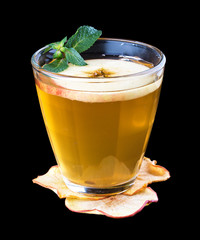 Hot tea with sea buckthorn and apple. In a glass cup on a dark background