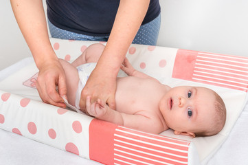 Mother is changing diaper to her little baby