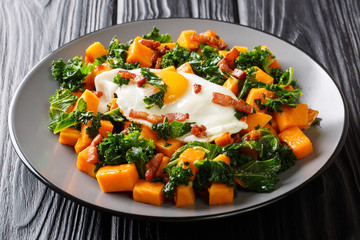 Organic sweet potato with kale cabbage, bacon and fried egg close-up on the table. horizontal