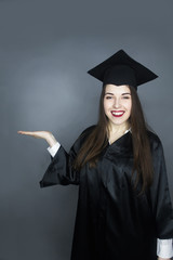 happy female graduate in cap and graduation gown