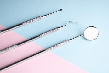 Dental instrments on pink and blue. Dental care concept. Dental treatment.