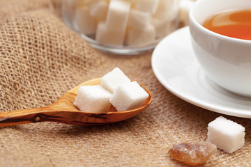 Glass cup of hot tea with sugar on the table